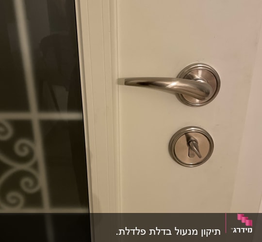 דלת לבנה עם ידית מתכתית וצילינדר עם כפתור נעילה